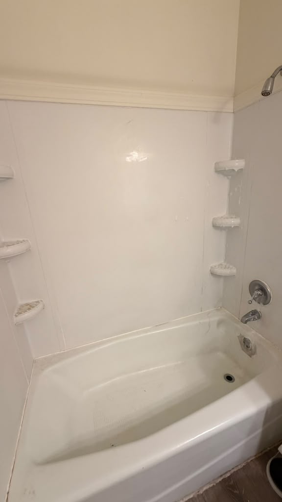 Clean white bathtub and shower walls