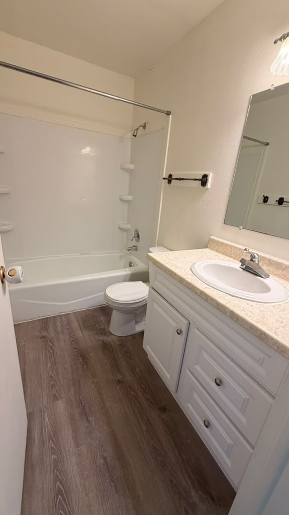 Clean bathroom with tub, toilet and white vanity after a cleaning
